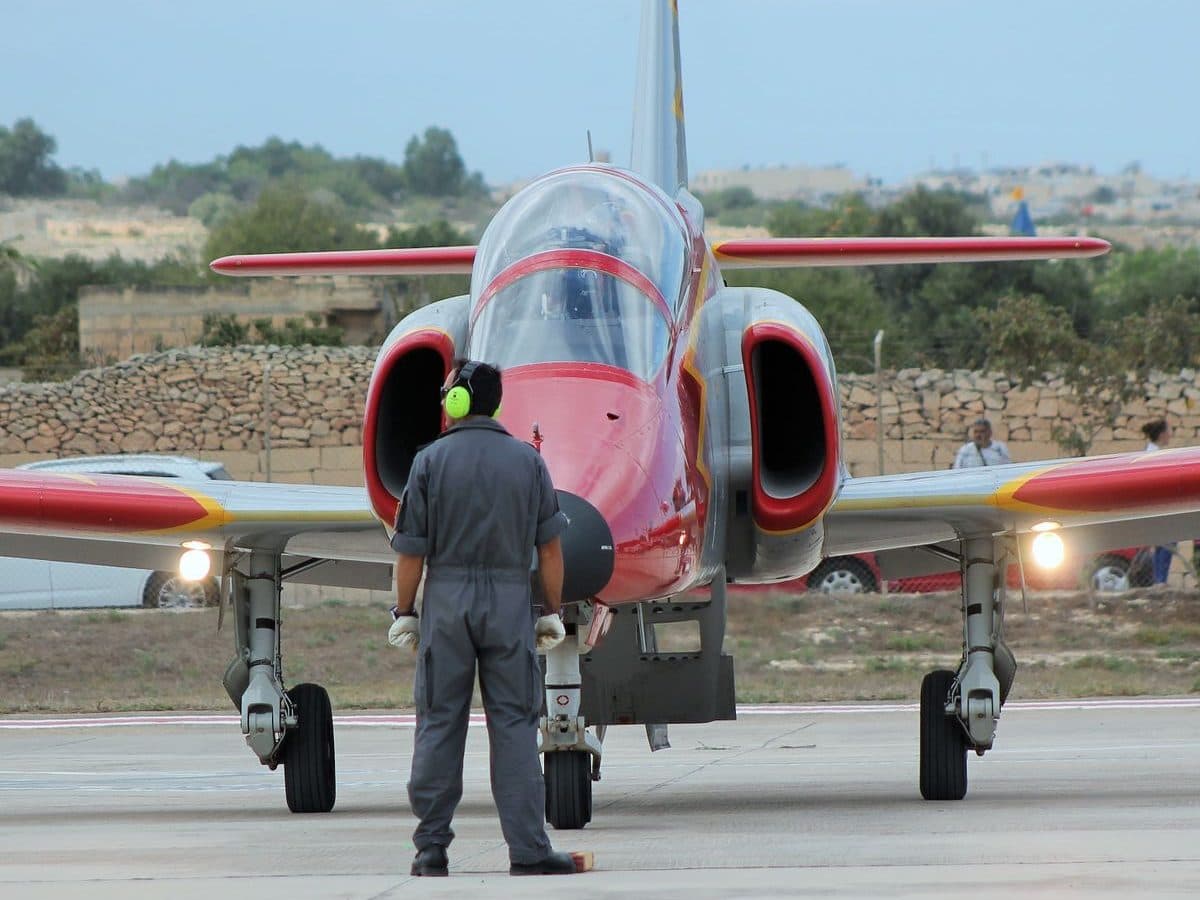 Flight line crew member marshalling an aerobatic display jet on the tarmac